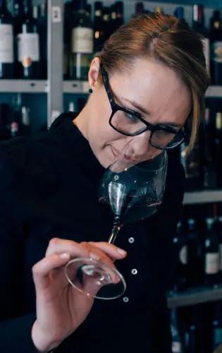 Linda Sorby doftar på ett rödvin i ett glas 