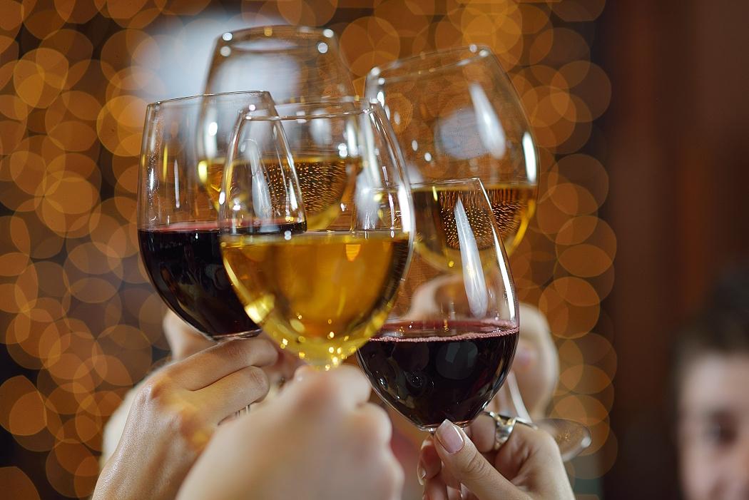 Celebration. Hands holding the glasses of champagne and wine making a toast.
